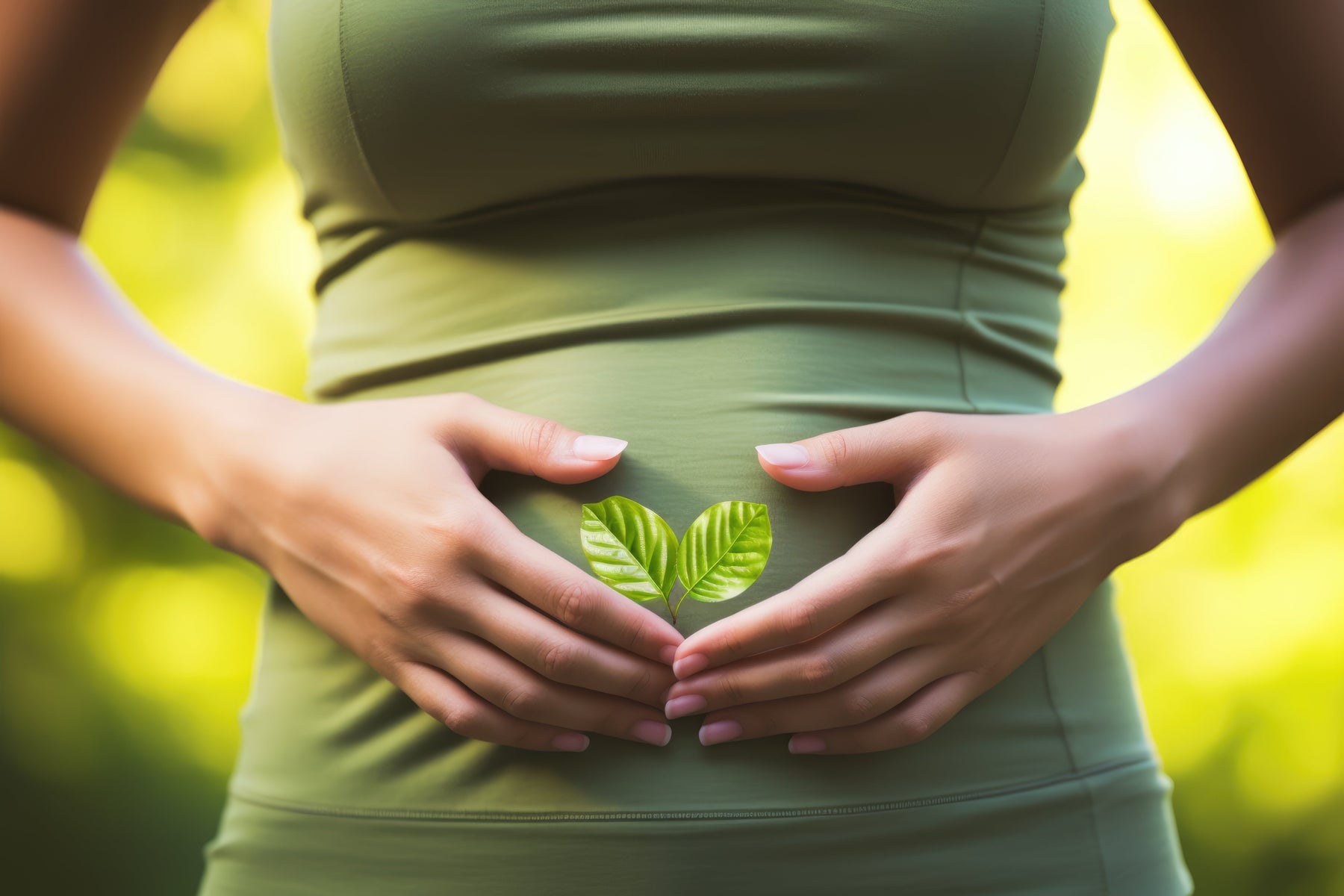 woman with hands in shape of heart over a stomach