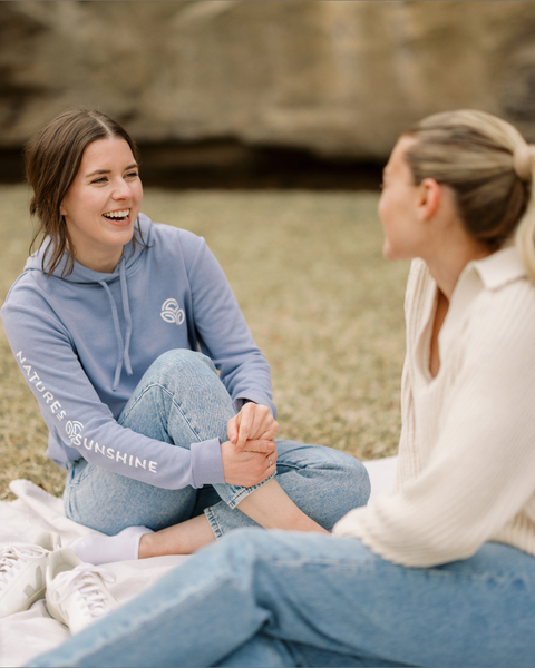 Two girls sitting outside talking together