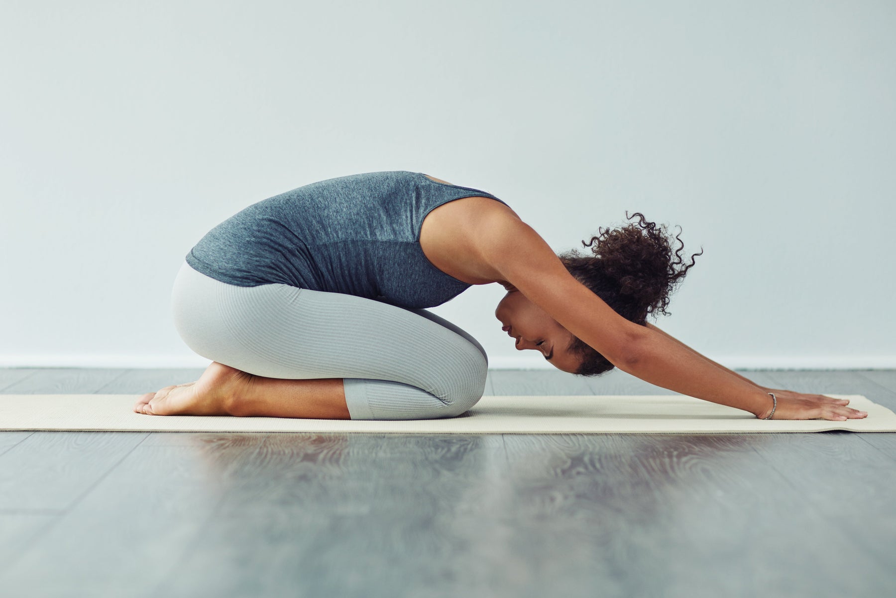 Healthy women in activewear doing downward dog yoga pose